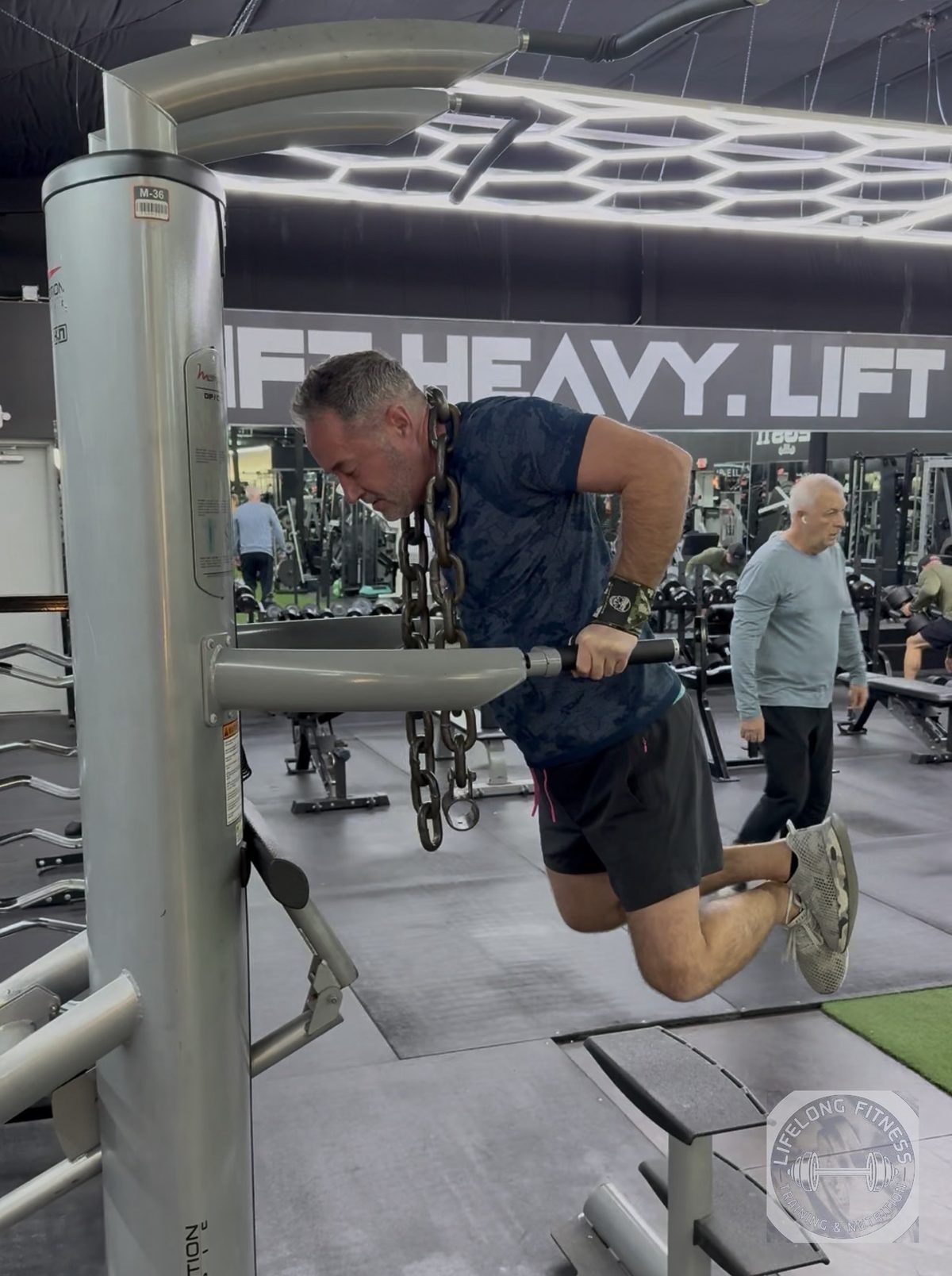 Client doing weighted dips with chains at Rise Gym