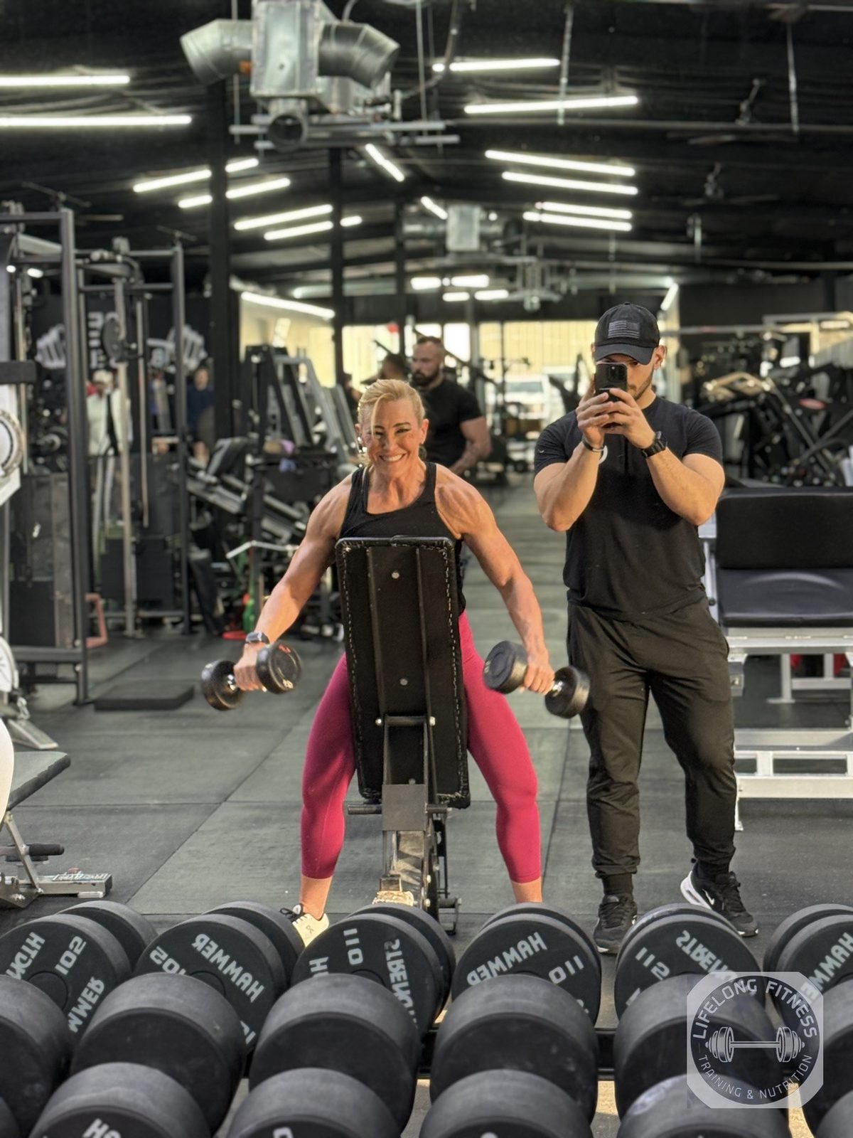 Client doing chest-supported dumbbell rows while Ozzy films