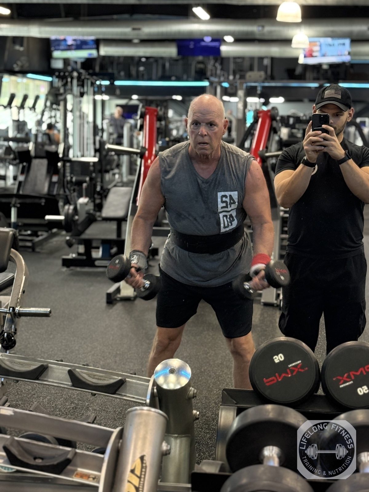 Coach Ozzy training client with dumbbells at Rise Gym