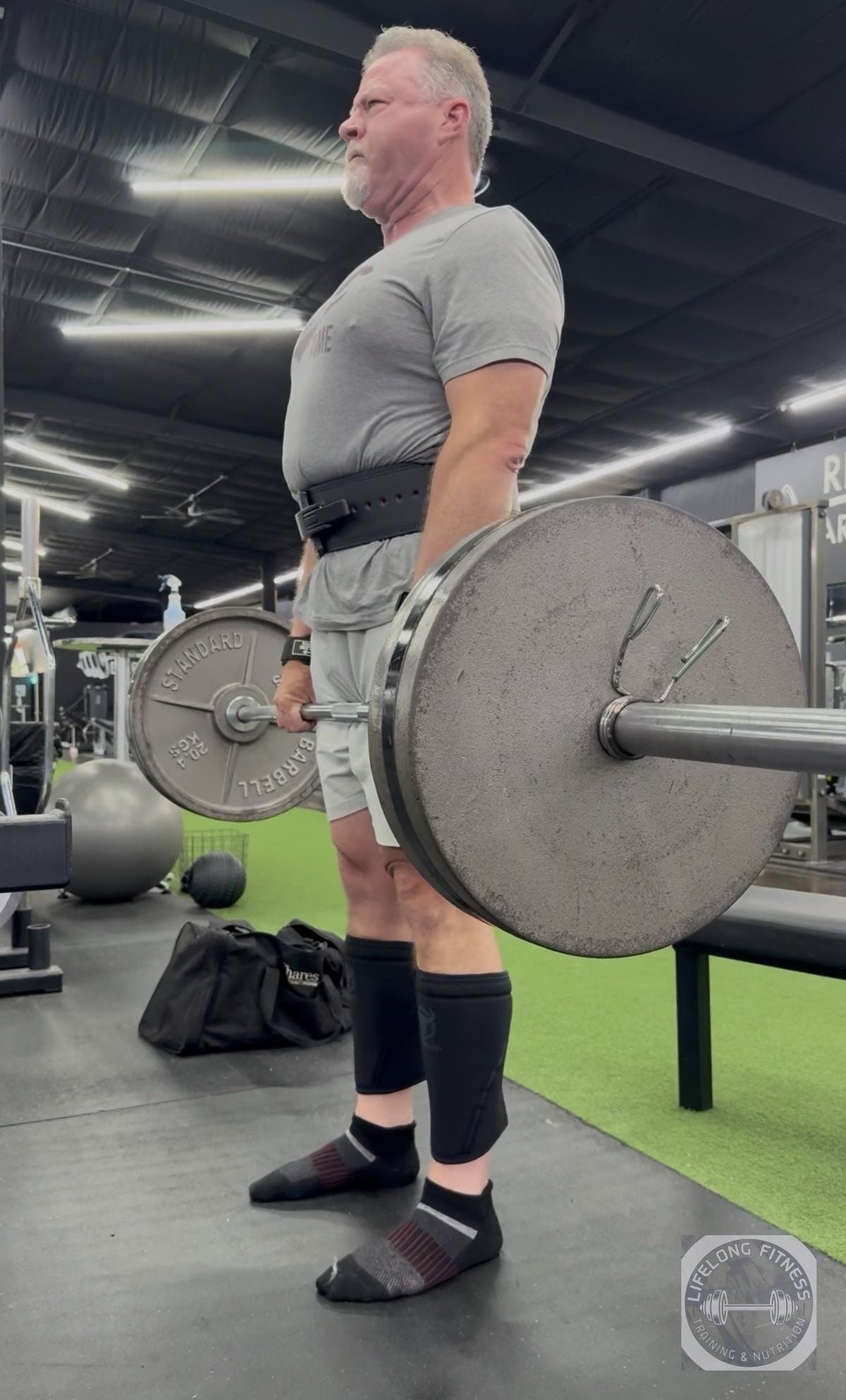 Older client deadlifting a loaded barbell at Rise Gym